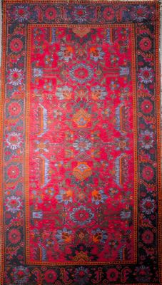 a red and blue rug with a floral design on it