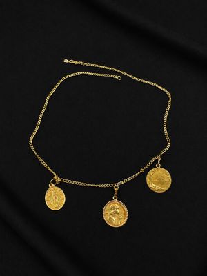 un collier en or orné de trois pièces d'or sur fond noir