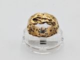 a close up of a gold ring on a clear surface
