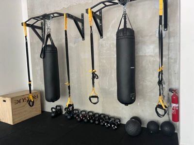 une salle de sport équipée d'un sac de frappe et d'autres appareils de musculation