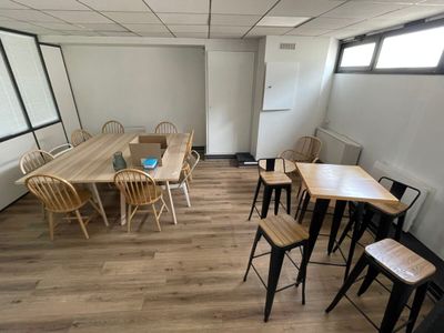 une pièce avec une table, des chaises et un réfrigérateur