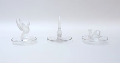 trois bougies en verre sont posées les unes à côté des autres sur une surface blanche