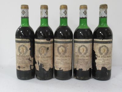 four bottles of wine are lined up on a white surface