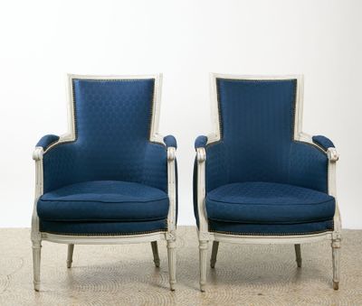 une paire de fauteuils rembourrés bleus avec des finitions blanches