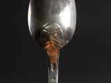 a silver spoon with a silver handle on a black surface