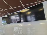 three televisions mounted on the wall in a large room