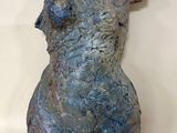 une sculpture représentant une femme assise sur une table