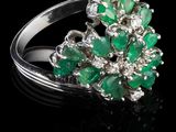 un gros plan d'une bague sertie d'émeraudes et de diamants