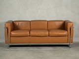 an image of a brown leather couch sitting on top of a cement floor