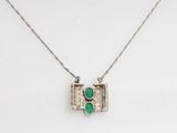 a close up of a necklace on a white surface with a green light