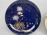 a plate with a picture of a bird and flowers on it