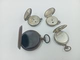 four different types of pocket watches on a white surface