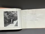 an open book with a black and white photo of a man standing on a path
