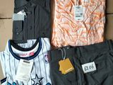 trois chemises pour homme posées sur une boîte en carton avec une étiquette de prix