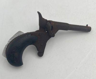 an old gun that is sitting on a white surface