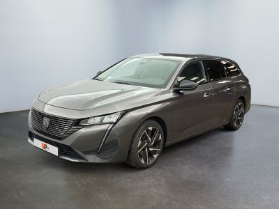 Une voiture grise est garée dans une pièce au sol noir.