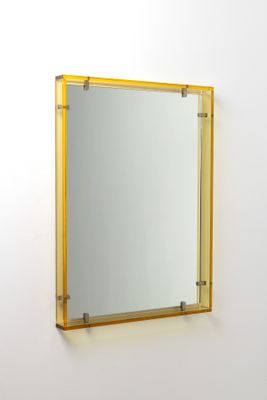 miroir accroché au mur dans une pièce blanche, avec un cadre jaune