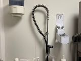 a kitchen sink with a faucet, soap, and other cleaning supplies