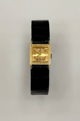 un gros plan d'une montre sur une surface blanche avec un fond blanc