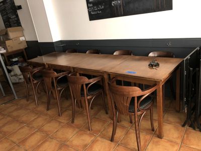 des tables et des chaises dans un restaurant, avec un tableau noir accroché au mur