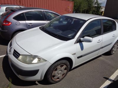 une voiture blanche garée dans un parking à côté d'autres voitures