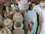 a cardboard box full of china and china dishes
