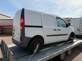 une camionnette blanche en train d'être chargée sur une remorque à plateau
