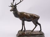 a bronze statue of a stag standing on a marble base