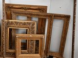 a lot of picture frames that are sitting on the floor