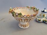 a small bowl with flowers on it next to a salt and pepper shaker