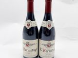 deux bouteilles de vin rouge posées l'une à côté de l'autre sur une surface blanche
