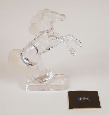 crystal figurine of a horse on a stand with a card