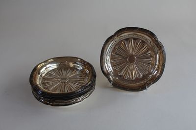 pair of antique glass ashtrays on a white background