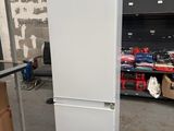 un réfrigérateur blanc entreposé dans un entrepôt avec d'autres articles