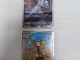two pokemon cards sitting on top of each other on a table