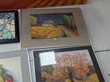 several paintings of different colors and sizes are on display on the floor