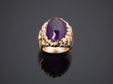 une bague en or sertie d'une pierre d'améthorate au centre