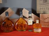 three bottles of liquor sitting on a table next to a wooden box