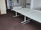 une pièce équipée de deux tables et d'un réfrigérateur
