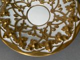 a white and gold plate with gold flowers on it