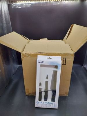 a cardboard box that has a knife and a bottle inside of it