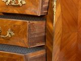 a wooden chest of drawers with a marble top