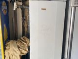 deux réfrigérateurs et un congélateur dans un garage