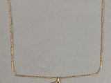 un collier en or avec une pièce de monnaie sur une chaîne