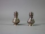 pair of silver salt and pepper shakers on grey background