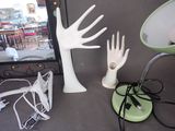 a table with a lamp and a hand statue on it