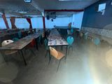 many tables and chairs in a room with a lot of windows