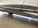 a white car parked in a garage with its door open
