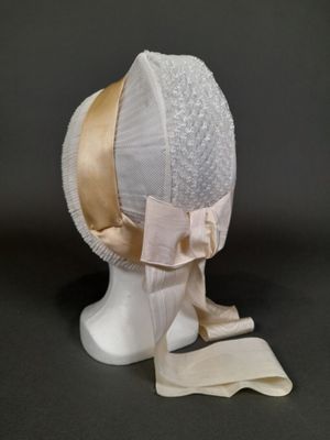 un chapeau blanc orné d'un ruban rose sur le dessus