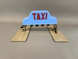 a blue taxi sign sitting on top of a pair of skis